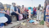 বইমেলায় আবর্জনার সামনে বসে বিশ্রাম দর্শনার্থীর